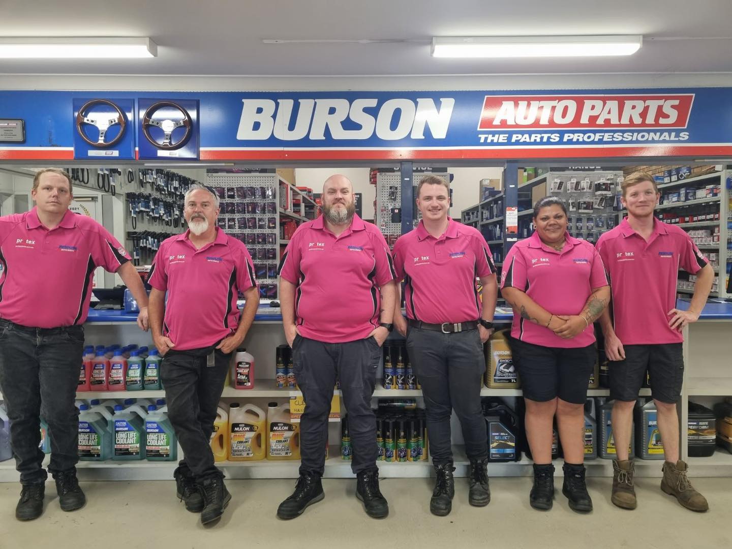 Burson Auto Parts team wearing pink shirts in store