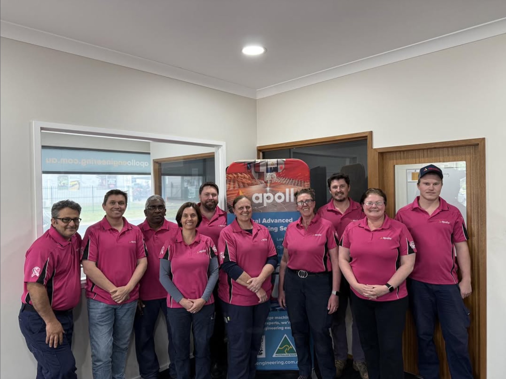 Team in pink shirts at their office
