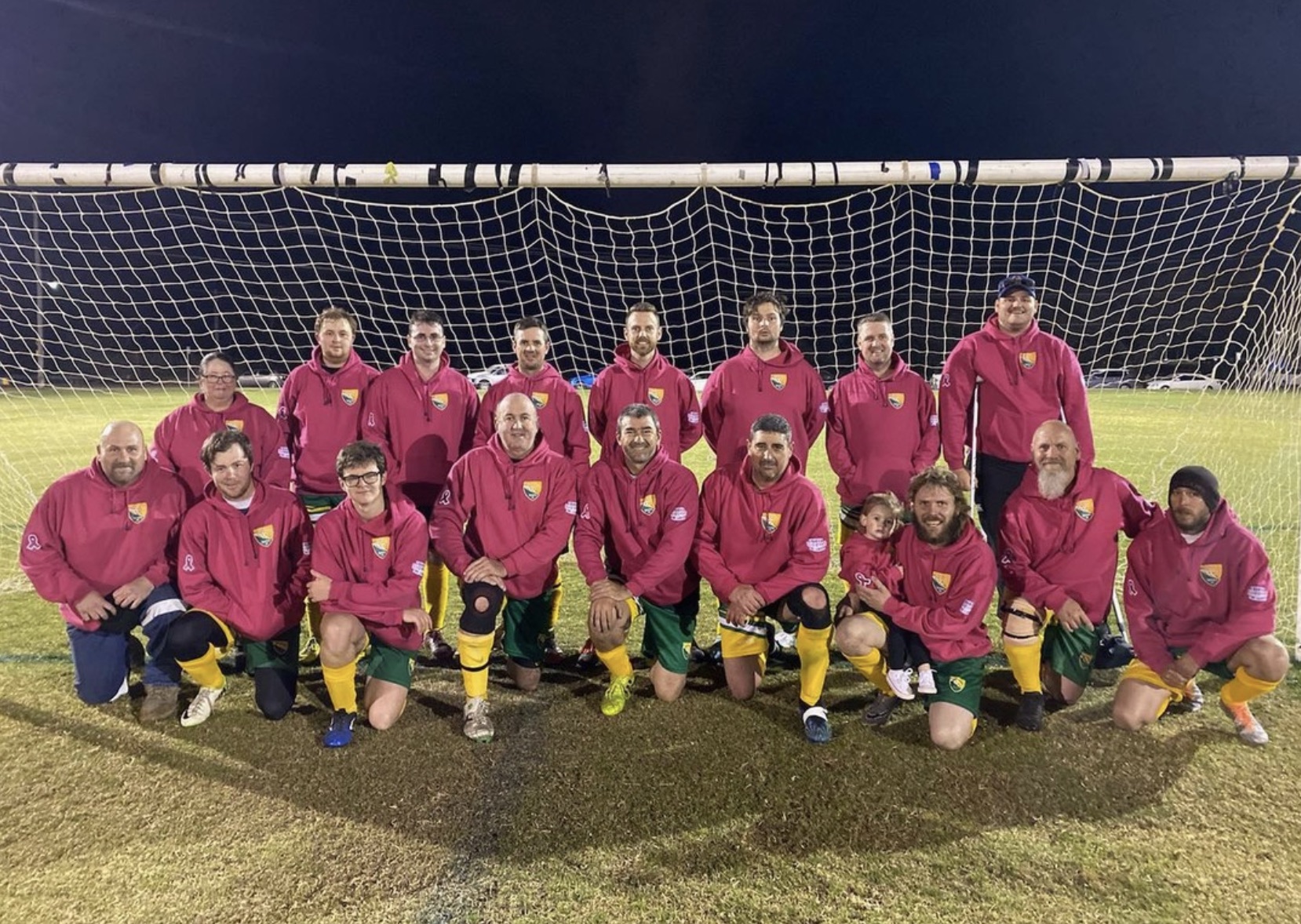 Football team wearing pink jumpers on the field